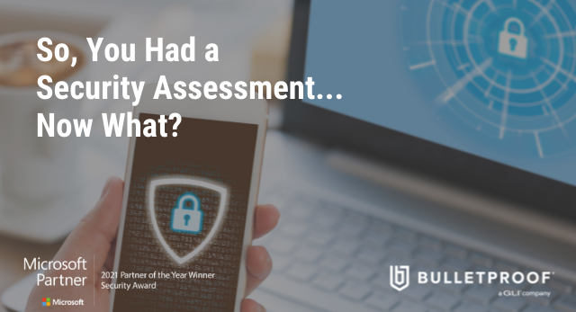 So You Had a Security Assessment is written in white font atop an image of a hand holding a smartphone up in front of a laptop.